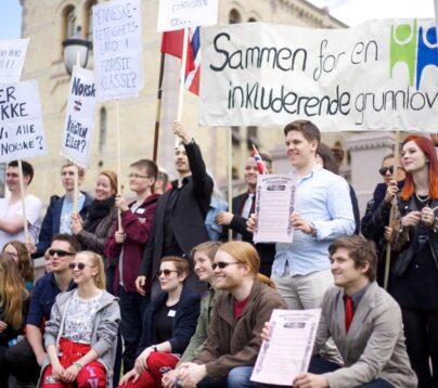 Bildet viser en gruppe ungdommer under en demonstrasjon foran stortinget. De holder et banner med logoen til human etisk ungdom.