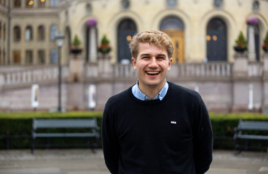 styreleder i LNU, Jakob står litt fremoverlent, leende fornøyd foran stortinget.