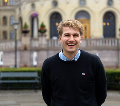 styreleder i LNU, Jakob står litt fremoverlent, leende fornøyd foran stortinget.